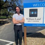 Chris Vogel standing next to William Land Park sign